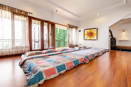 a large bed in a room with a large window at Dapur Caringin Tilu Villa in Arcamanik