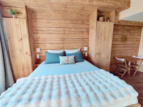 a bedroom with a large bed and a wooden wall at Le Petit Oingt de Paradis Chambre d'hôtes in Oingt