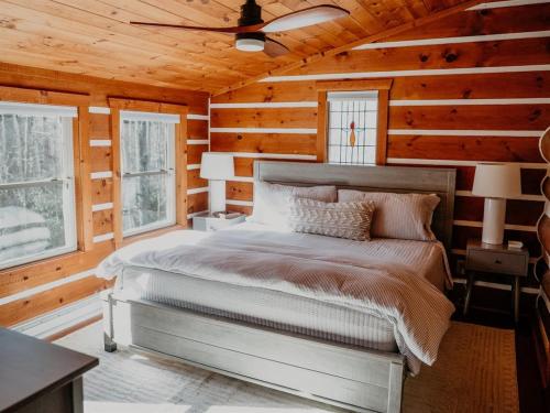 a bedroom with a bed in a wooden cabin at Hemlock Hill Cabin in Blowing Rock