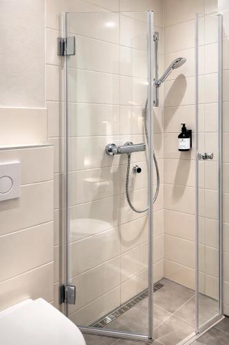 a shower with a glass door in a bathroom at S'Matt Bob in Feldkirch