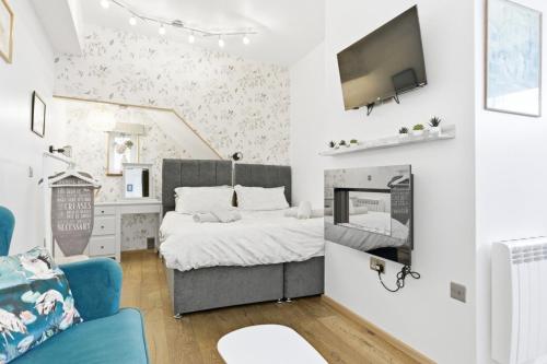 a bedroom with a bed and a tv on a wall at Shiny Pebble in Southwold