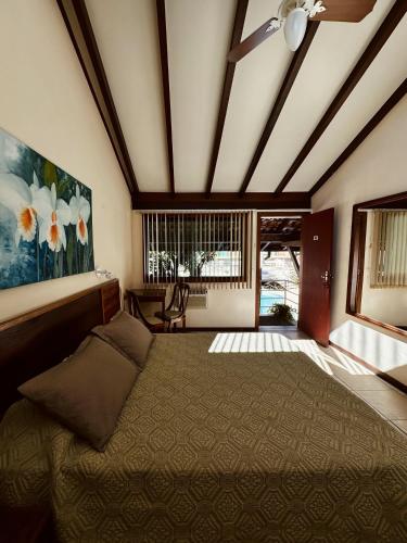 a bedroom with a large bed and a ceiling at Hotel Dominguez Plaza in Nova Friburgo