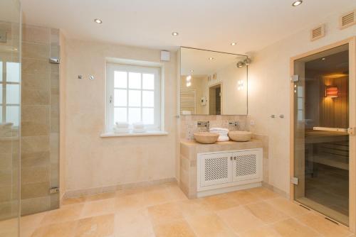 a bathroom with two sinks and a glass shower at Haus-Meerblick in Rantum