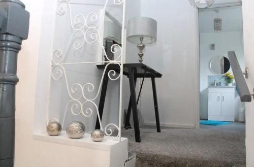 a room with a table with a lamp and a mirror at Limewood Townhouse in Londonderry County Borough