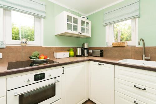 a kitchen with white cabinets and a sink at Bandomir-Bungalow-Wohnung-02 in Westerland