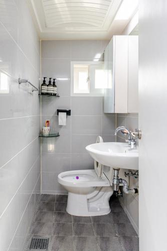 a white bathroom with a sink and a toilet at 코지룸 in Seoul