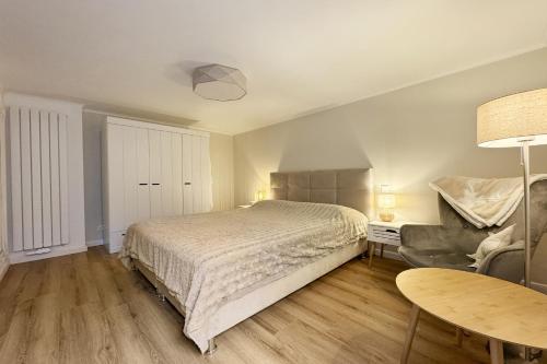 a bedroom with a bed and a chair and a table at Haus-Excelsior-Wohnung-08 in Rantum