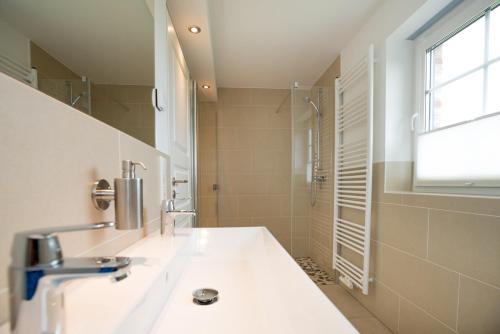 a bathroom with a sink and a shower at Haus-Seestern in Tinnum