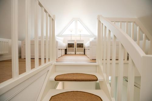 a white staircase in a home with a window at Haus-Seestern in Tinnum