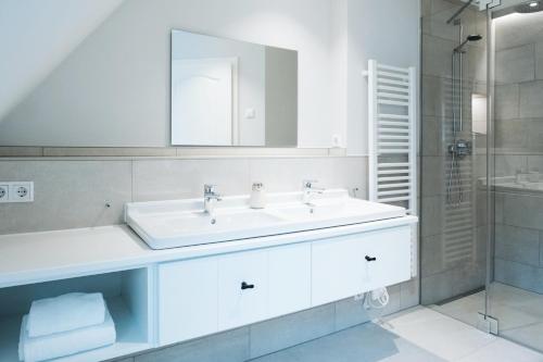 a white bathroom with a sink and a shower at Stadtrose in Westerland