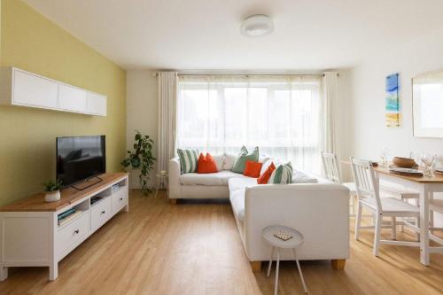 a living room with a couch and a tv at Sunny & Modern Near the Beach & Village w Parking in East Wittering