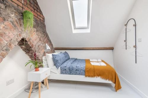 a bedroom with a bed and a brick wall at Arty House with Garden in Central Bristol in Bristol