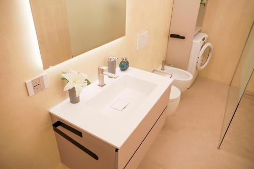 a bathroom with a sink and a toilet and a mirror at BLUE WAVE by Design Studio in Bellano