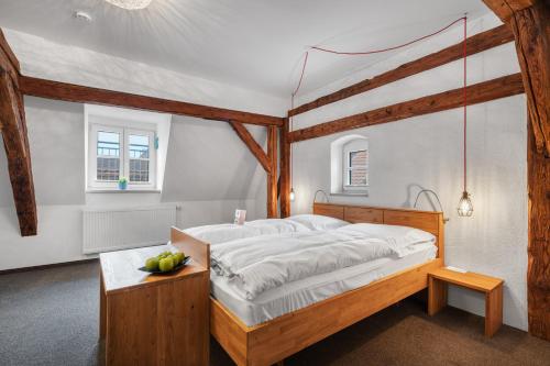 a bedroom with a large bed with a wooden frame at Schieners Hotel & Apfelhof Apartments in Wemding