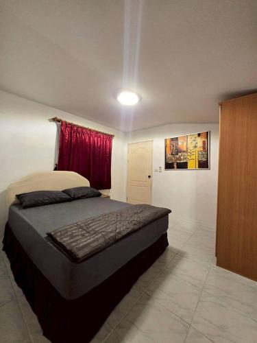 a bedroom with a bed and a red window at Red House 12 in Ban Nong Pru