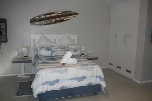 a white bedroom with a bed with a boat on it at 6 Bayview Seaside Apartment in East London