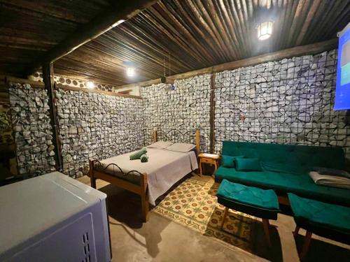 a room with a bed and a couch at Chalé Medieval in Brumadinho