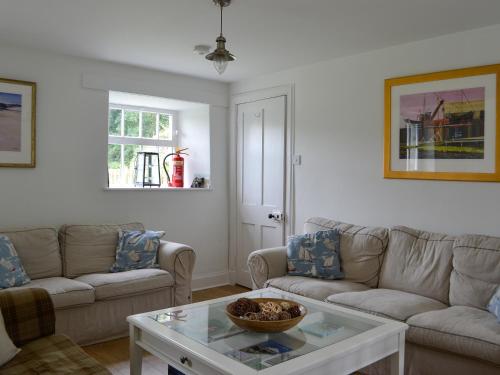 a living room with two couches and a coffee table at Orchard Cottage - Uk12525 in Garlieston