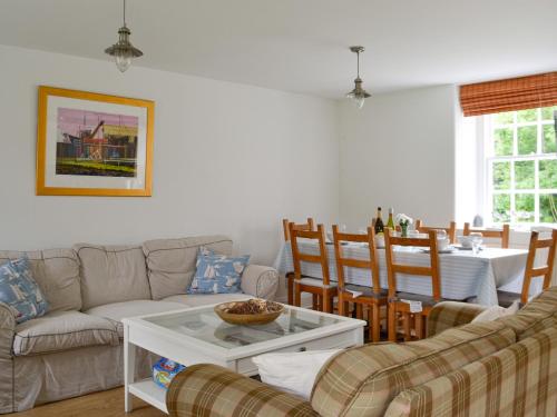 a living room with a couch and a table at Orchard Cottage - Uk12525 in Garlieston