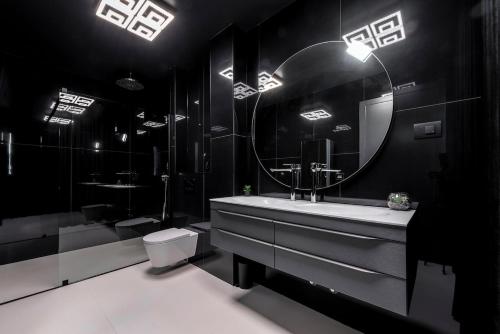 a black bathroom with a sink and a mirror at Luxury Villa Black Cube with Heated pool in Mlini