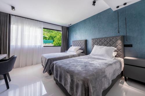 a bedroom with two beds and a window at Luxury Villa Black Cube with Heated pool in Mlini