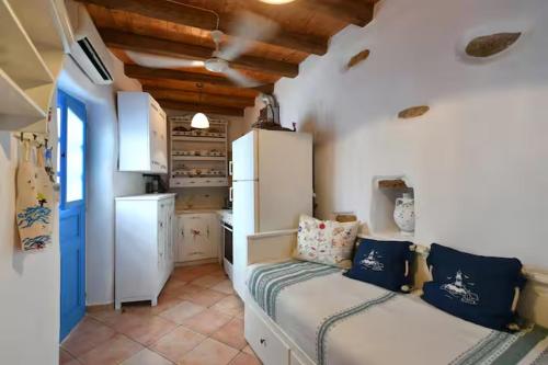 a small kitchen with a bed and a refrigerator at Maison d'Elli in Mesochórion