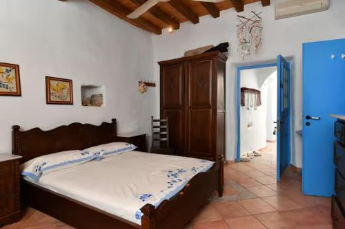 a bedroom with a bed and a blue door at Maison d'Elli in Mesochórion