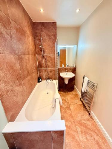 a bathroom with a bath tub and a sink at Perfect City Flat for Leisure & Work stays in Bristol