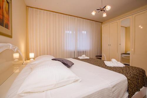 a bedroom with a large bed with two towels on it at Jednosobni apartman Dionis in Mundanije