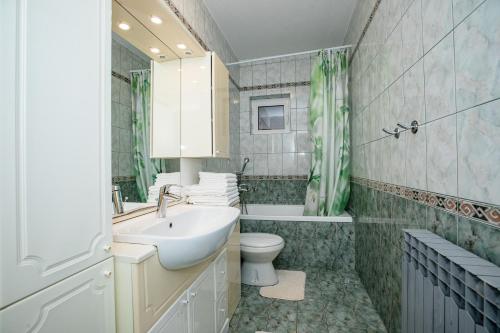 a bathroom with a sink and a toilet and a tub at Jednosobni apartman Dionis in Mundanije