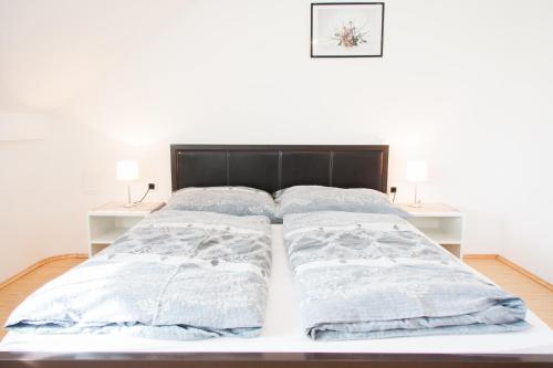 a bed with two pillows on top of it at Rooms Garden Zagreb Airport in Velika Gorica