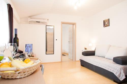 a living room with a couch and a basket of fruit at Rooms Garden Zagreb Airport in Velika Gorica