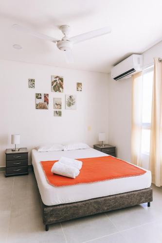 a bedroom with a large bed with an orange blanket at Casa Bethel 92 in Ricaurte