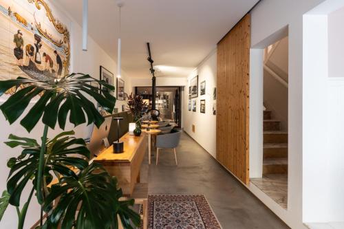 a living room with a potted plant and a staircase at O VIOLAS - Art Coffee & Guesthouse in Praia de Mira