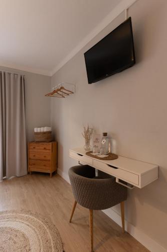 a room with a desk with a television on the wall at O VIOLAS - Art Coffee & Guesthouse in Praia de Mira