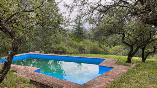 a swimming pool in a yard with trees at El Campito in Villa Icho Cruz