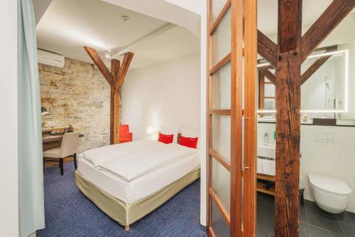 a bedroom with a bed and a desk in a room at Tailormade Hotel RÜDEN Schaffhausen in Schaffhausen