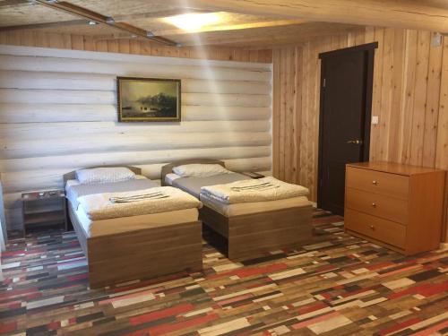 a room with two beds and a dresser in it at Abyrvalg Hotel in Issad