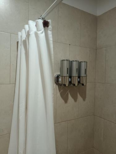 a shower with a white shower curtain in a bathroom at Mi Espacio en Gualeguaychú in Gualeguaychú
