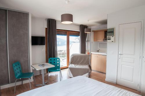 a bedroom with a bed and a table and chairs at La villa Du Port in Veyrier-du-Lac