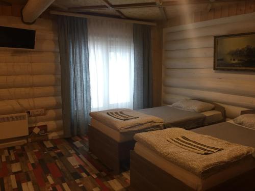 a room with three beds and a window at Abyrvalg Hotel in Issad