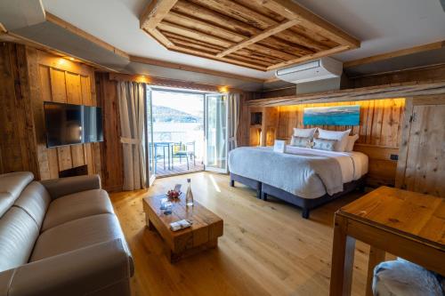 a bedroom with a bed and a couch in a room at Hôtel La Maison Bleue par Yoann CONTE in Veyrier-du-Lac