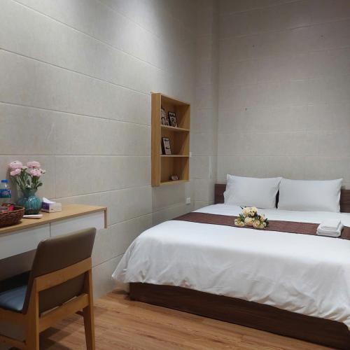 a bedroom with a bed and a table and a chair at Omeli homestay in Hanoi
