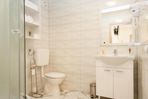 a white bathroom with a toilet and a sink at Rooms Garden Zagreb Airport in Velika Gorica