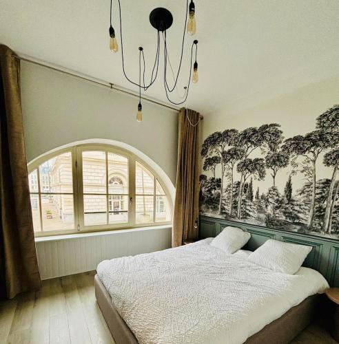 a bedroom with a bed and a large window at La Scène Audomaroise - Appartement hyper centre in Saint-Omer