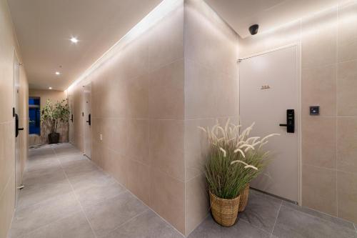 a hallway with a tile wall and a potted plant at 4rest Stay Euljiro in Seoul