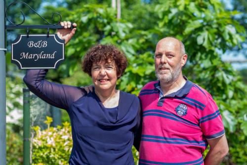 a man and a woman standing next to a sign at Bed & Breakfast Maryland in Asten-Heusden