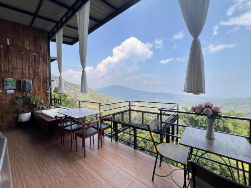 a balcony with tables and chairs and a view at ม่อนสาเคียงดาว in Ban Thung Phan Ha