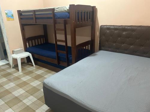 a bedroom with two bunk beds and a stool at Kitnet Cantinho 26 in Mongaguá