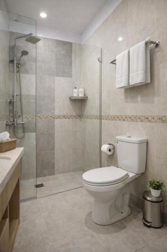 a bathroom with a toilet and a glass shower at Hotel YO94 in Indore
